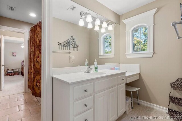 bathroom with visible vents, vanity, and baseboards