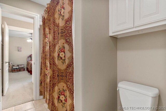 bathroom with toilet, a ceiling fan, tile patterned floors, and a shower with shower curtain