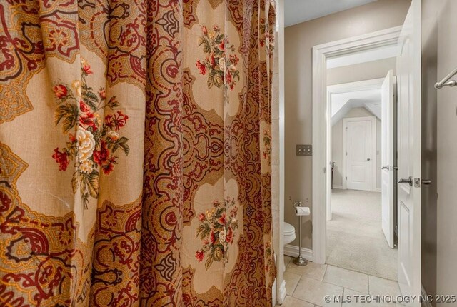 bathroom with tile patterned floors, baseboards, and toilet