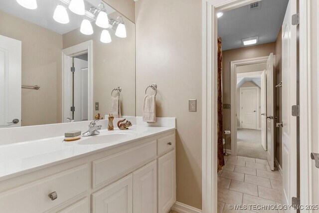 bathroom with visible vents, vanity, tile patterned flooring, and baseboards