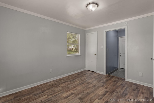 unfurnished bedroom featuring baseboards, dark wood-type flooring, and crown molding
