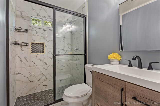 full bathroom featuring toilet, vanity, and a marble finish shower