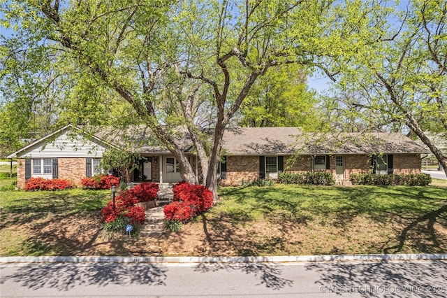 ranch-style home with brick siding and a front yard