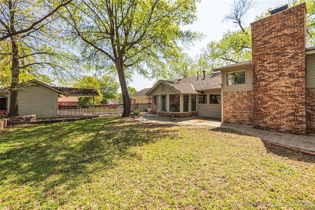 view of yard featuring an outdoor structure, fence, and a patio area