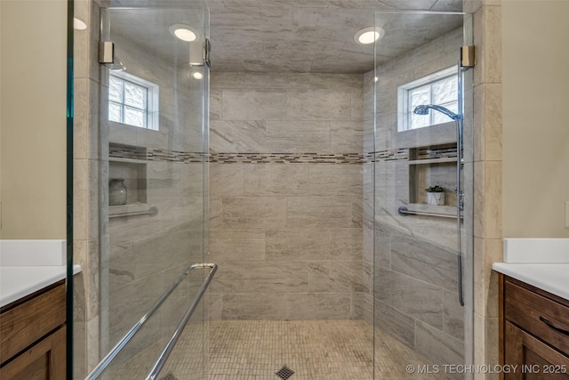 bathroom with a shower stall and vanity