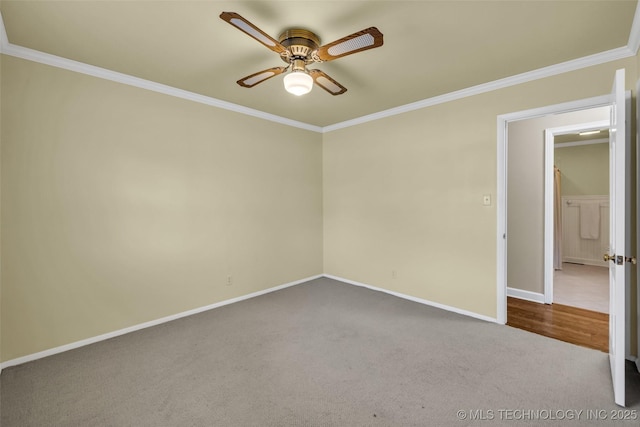 unfurnished room with a ceiling fan, baseboards, dark carpet, and crown molding