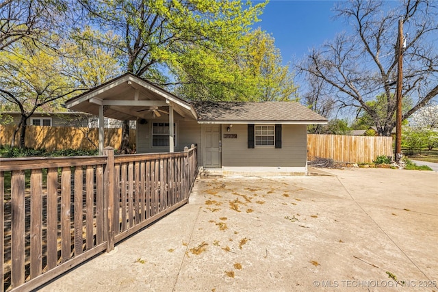 view of front facade with a ceiling fan, fence private yard, and driveway
