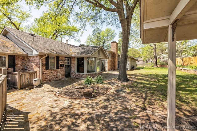 view of yard featuring a sunroom, a patio, and fence