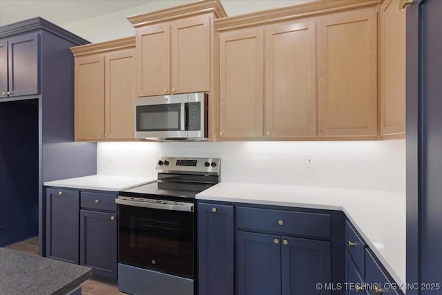 kitchen featuring light brown cabinets, decorative backsplash, appliances with stainless steel finishes, and light countertops