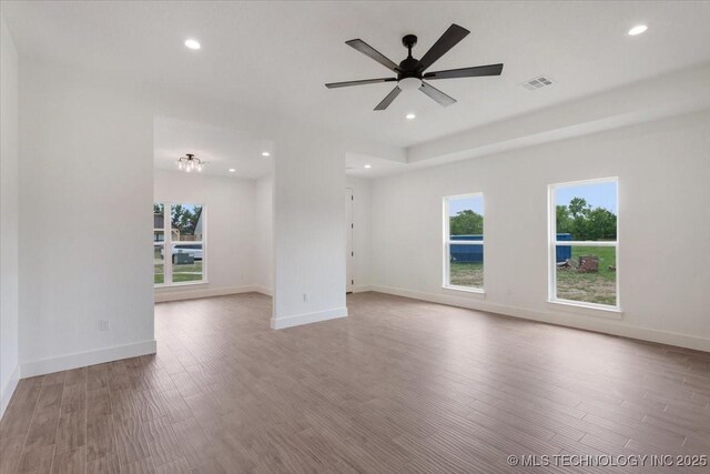 empty room featuring recessed lighting, plenty of natural light, visible vents, and wood finished floors