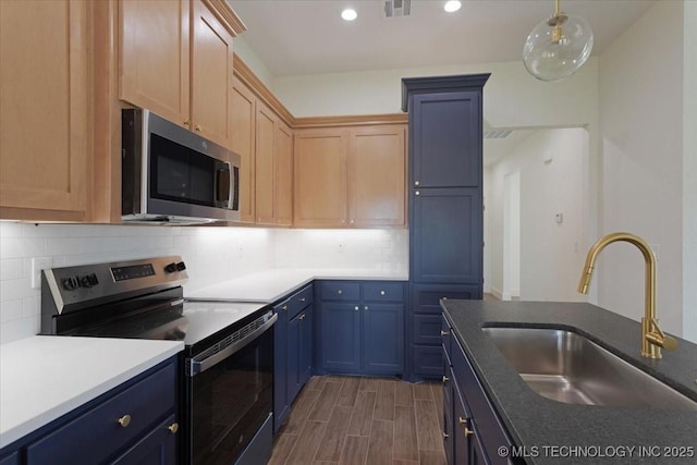 kitchen with visible vents, blue cabinets, a sink, tasteful backsplash, and appliances with stainless steel finishes