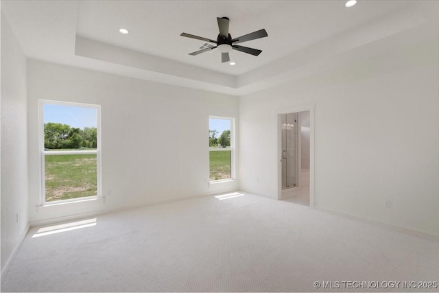 unfurnished bedroom with a raised ceiling, baseboards, recessed lighting, and carpet