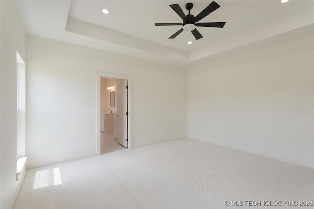 carpeted empty room featuring baseboards, a ceiling fan, a tray ceiling, and recessed lighting