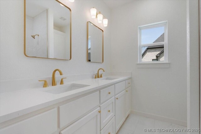 full bath featuring baseboards, a sink, and double vanity