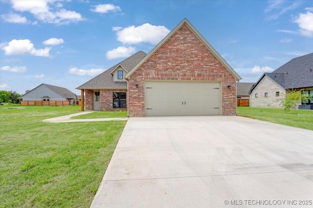 view of front of property with fence, an attached garage, driveway, brick siding, and a front yard