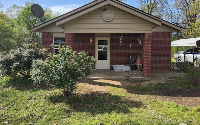 rear view of property featuring a detached carport and brick siding