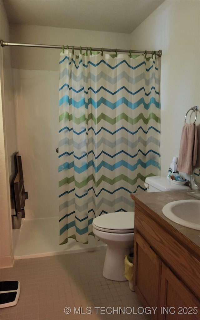 bathroom featuring toilet, a shower with curtain, vanity, and tile patterned floors