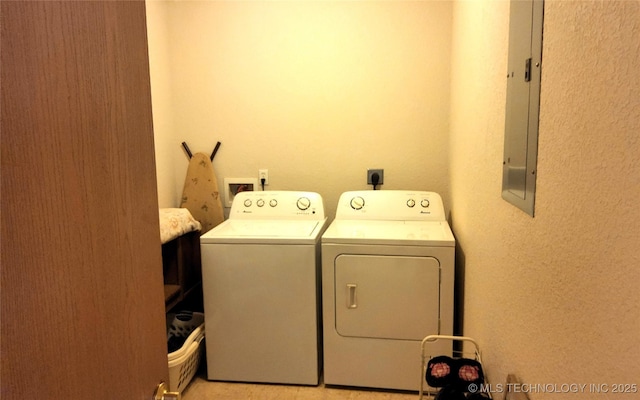 laundry area with a textured wall, electric panel, laundry area, and washer and clothes dryer