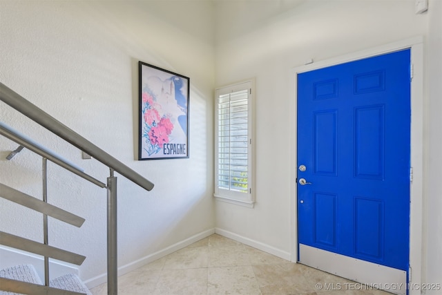 entryway with baseboards and light tile patterned floors