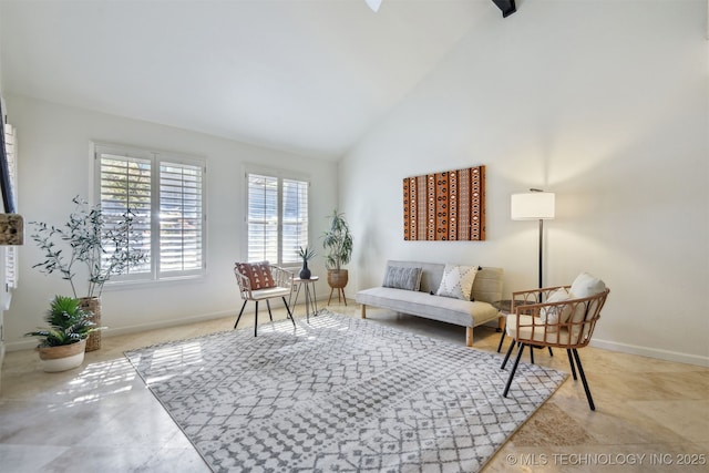 sitting room with high vaulted ceiling, baseboards, and tile patterned floors