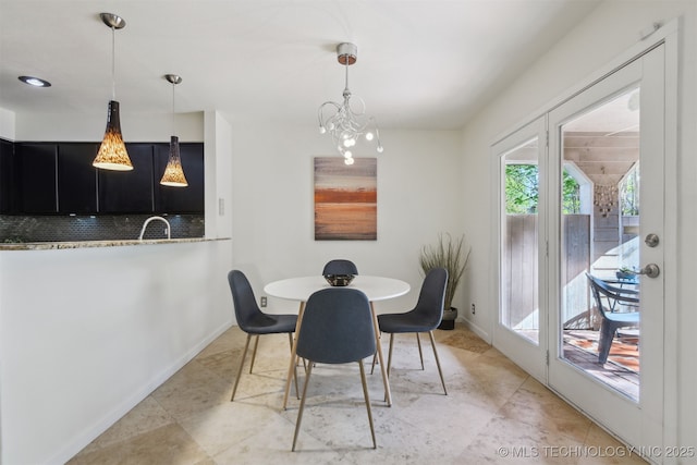 dining area with baseboards and a notable chandelier