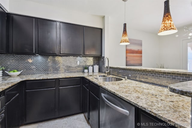 kitchen with dark cabinets, stainless steel dishwasher, a sink, light stone countertops, and tasteful backsplash