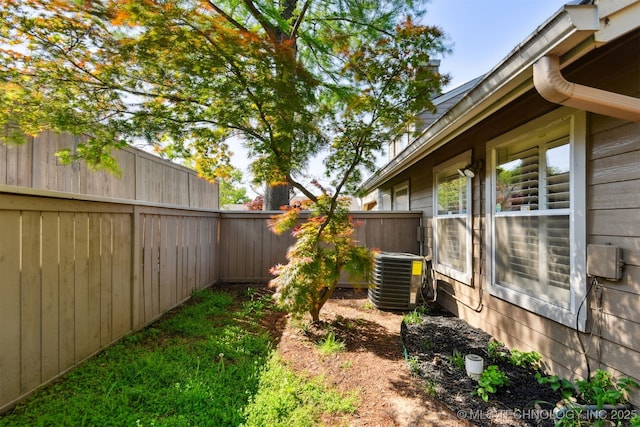 view of yard with a fenced backyard and central AC