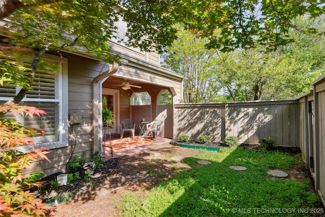 view of yard with ceiling fan, a fenced backyard, and a patio area