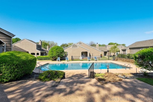 community pool with fence and a patio