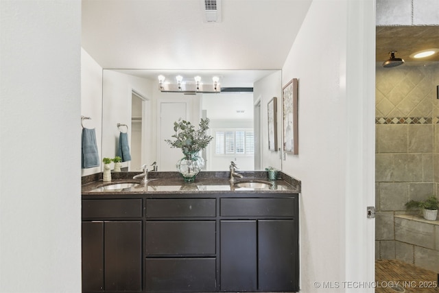 full bathroom featuring visible vents, a sink, and a shower stall