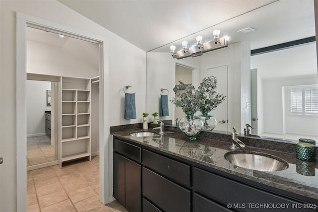 bathroom with tile patterned floors, a sink, visible vents, and double vanity