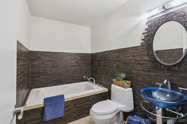 full bathroom featuring a garden tub, toilet, and a sink