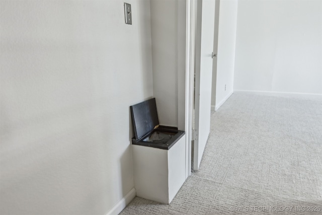 hall featuring baseboards and carpet flooring