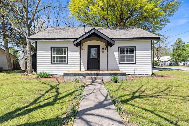 401 S Brewer St, Vinita, OK 74301 - bungalow with central air condition unit, roof with shingles, and a front lawn