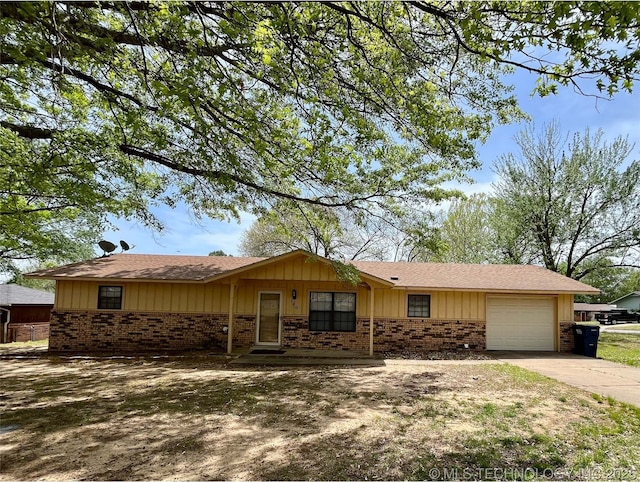 single story home featuring brick siding, a garage, board and batten siding, and concrete driveway