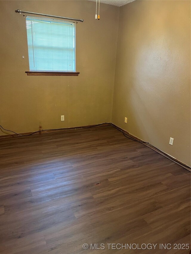 empty room featuring baseboards and wood finished floors