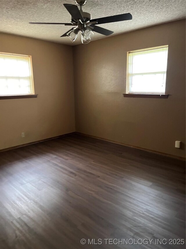unfurnished room featuring a textured ceiling, wood finished floors, and a wealth of natural light