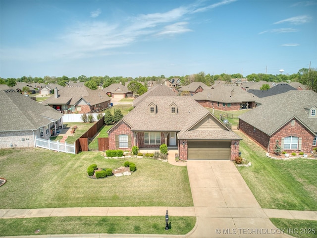 view of front of home with fence, a shingled roof, a residential view, an attached garage, and brick siding