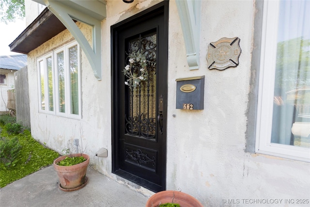 doorway to property featuring stucco siding