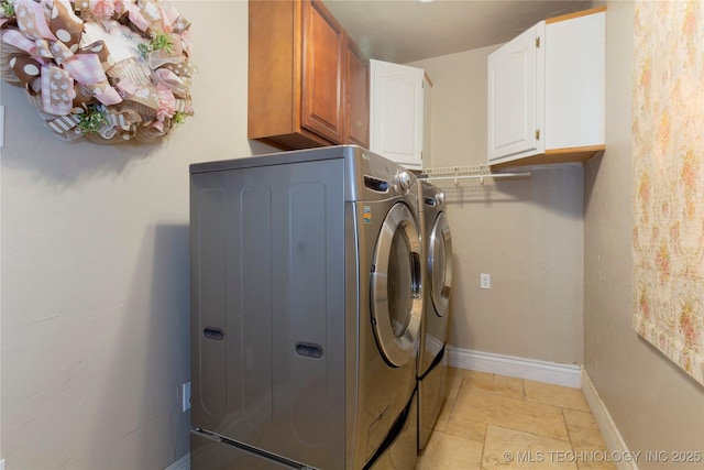 clothes washing area featuring washer and dryer, baseboards, cabinet space, and stone finish flooring