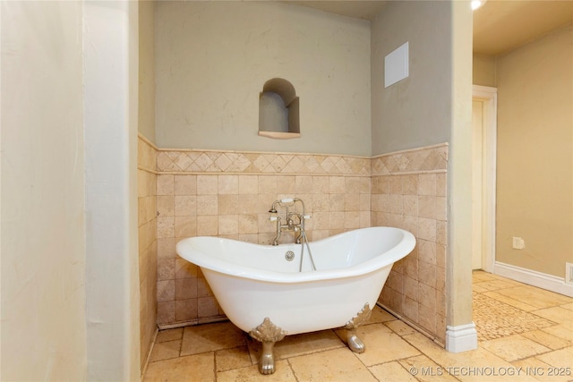bathroom with tile walls and a soaking tub