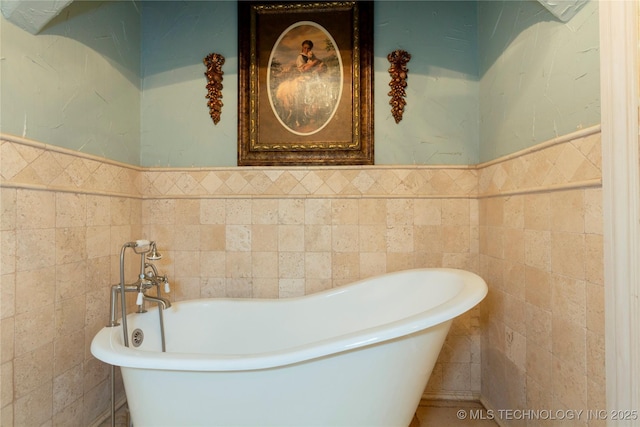 bathroom featuring wainscoting, a freestanding bath, and tile walls