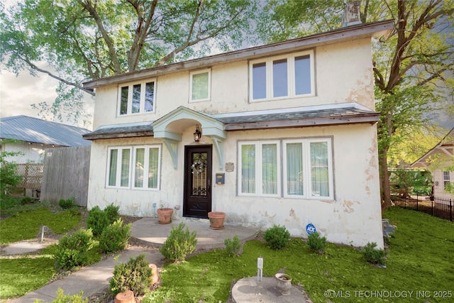 traditional-style home with stucco siding and fence