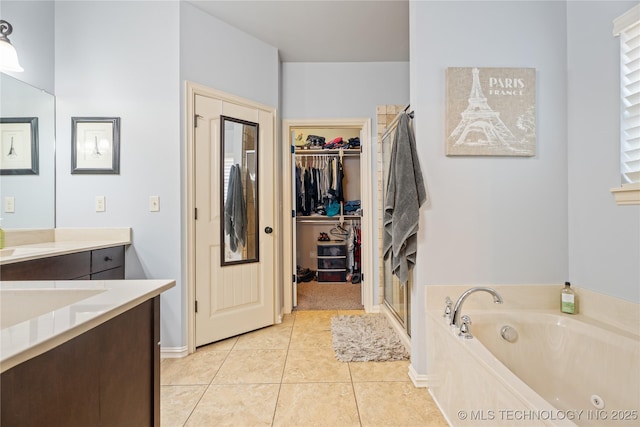 3235 Boardwalk Ct, Bartlesville, OK 74006 - bathroom with a spacious closet, tile patterned flooring, vanity, a garden tub, and a stall shower