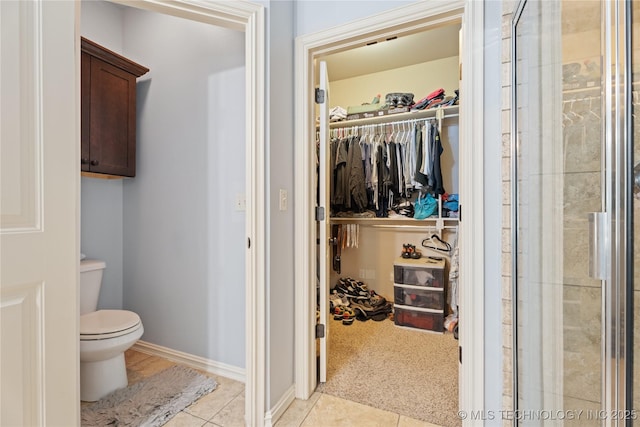 3235 Boardwalk Ct, Bartlesville, OK 74006 - bathroom with a walk in closet, toilet, tiled shower, and tile patterned floors