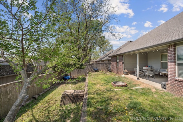 3235 Boardwalk Ct, Bartlesville, OK 74006 - view of yard with a patio area, a fenced backyard, and a fire pit
