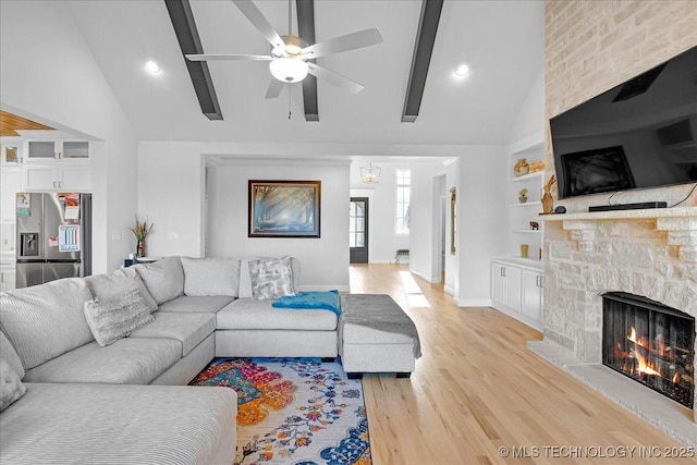 12754 S Irvington Ave, Tulsa, OK 74137 - living area with a stone fireplace, a ceiling fan, baseboards, light wood-style flooring, and high vaulted ceiling