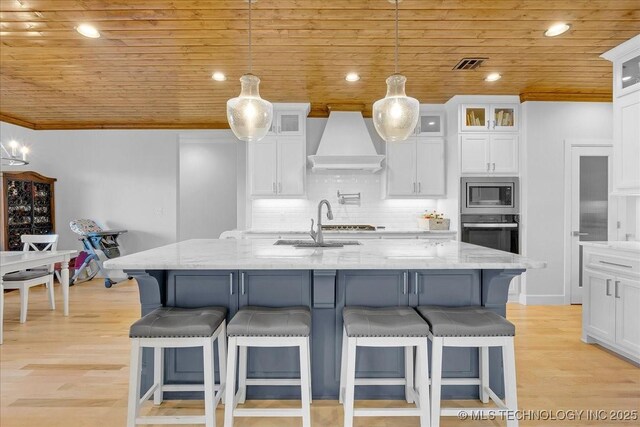 12754 S Irvington Ave, Tulsa, OK 74137 - kitchen featuring white cabinets, backsplash, custom range hood, wooden ceiling, and appliances with stainless steel finishes