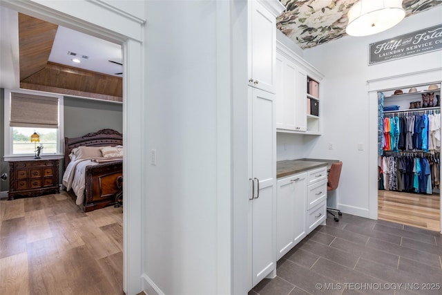 interior space featuring baseboards, dark wood-style flooring, and visible vents