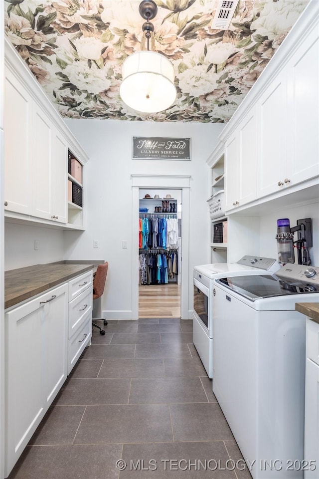 laundry area with baseboards, visible vents, washer and dryer, and cabinet space